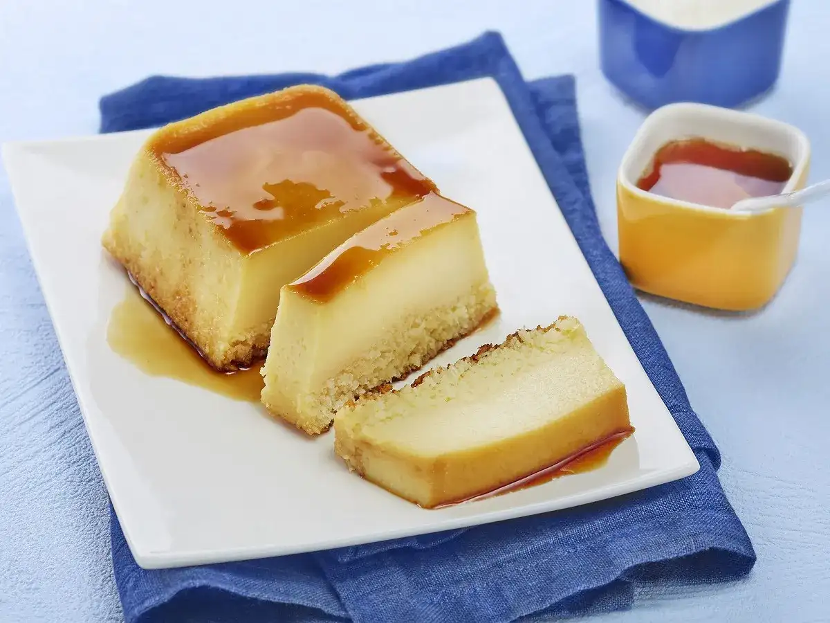 Un délicieux flan au lait concentré, parfait pour une recette flan lait concentré Nestlé. Servi sur une assiette blanche avec un coulis de caramel.